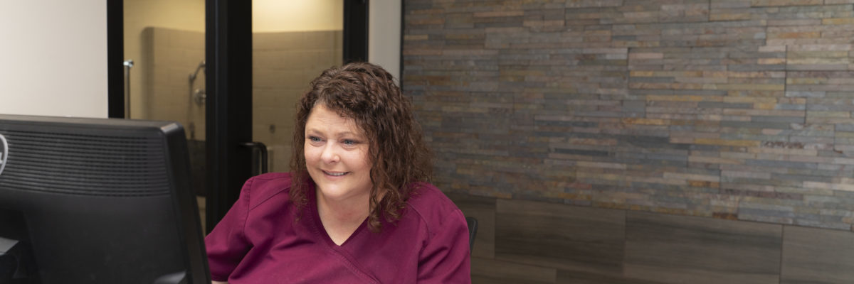 Meadowbrook Veterinary Clinic staff member working behind desk.